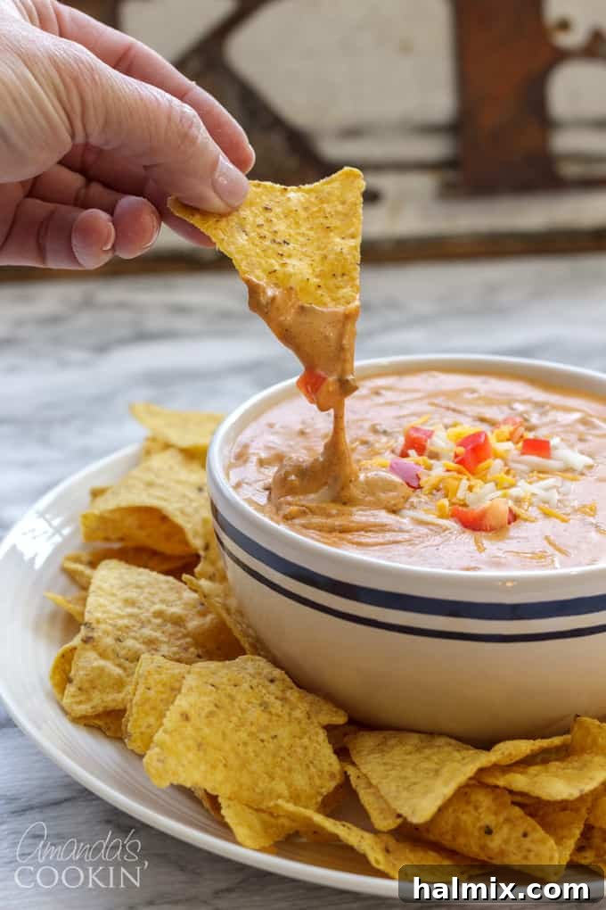 Rich, gooey chili cheese dip served with crispy tortilla chips, ready for a party.