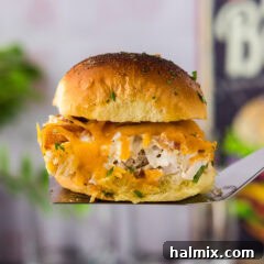 Close up photo of a Chicken Bacon Ranch Slider on a spatula, showcasing melted cheese