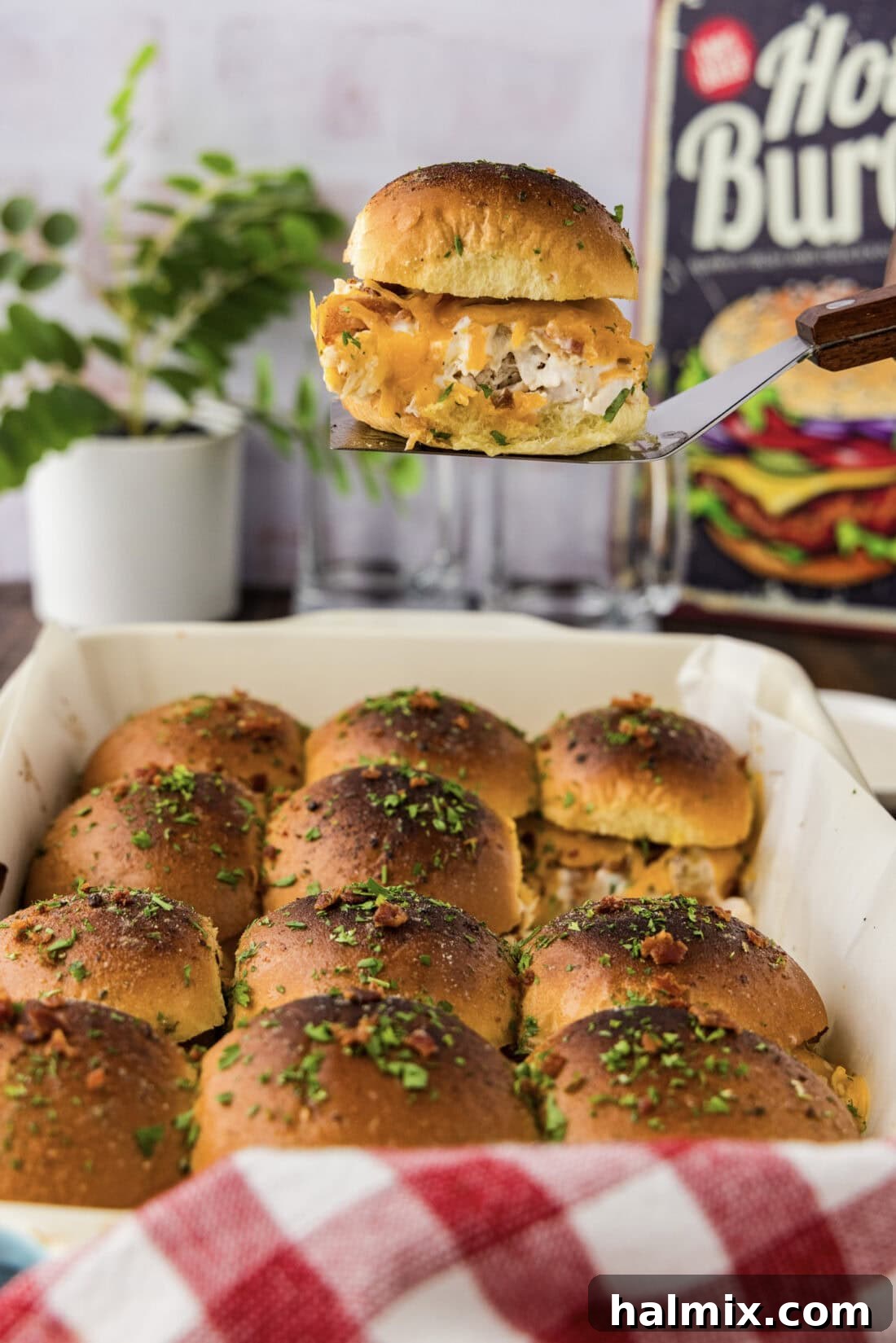 Spatula lifting a melty Chicken Bacon Ranch Slider from a baking dish