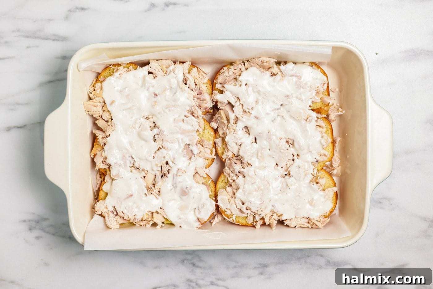 Ranch dressing drizzled over chicken on slider buns