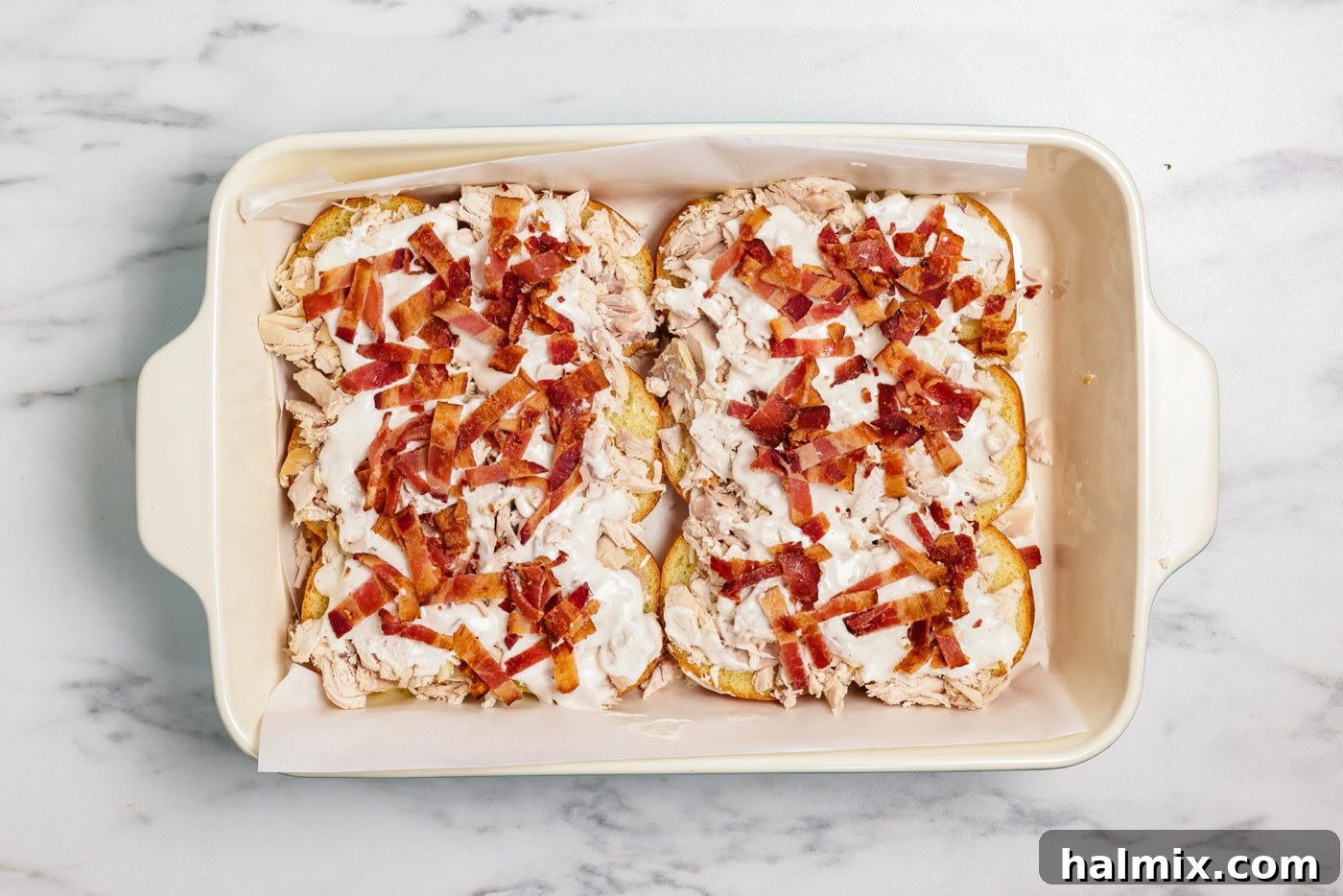 Chopped bacon sprinkled on top of ranch and chicken over slider buns