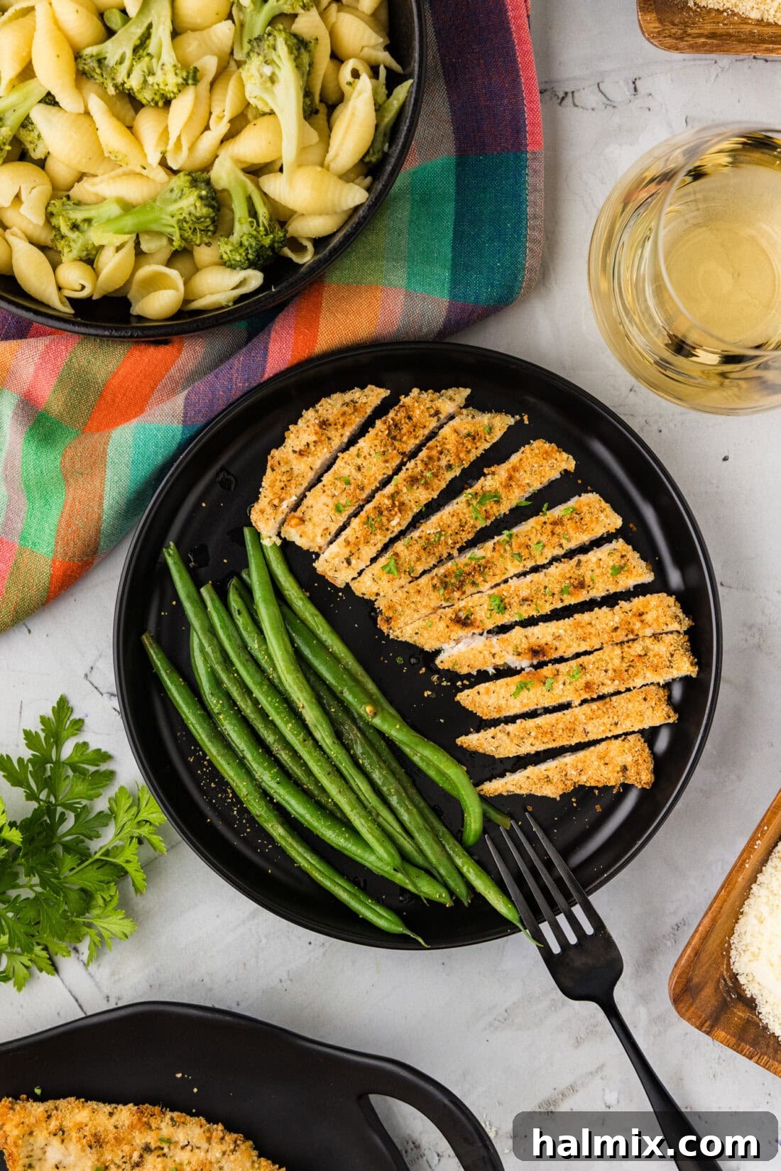 Crispy Parmesan Chicken 3 Sliced Parmesan Crusted Chicken on a plate with green beans