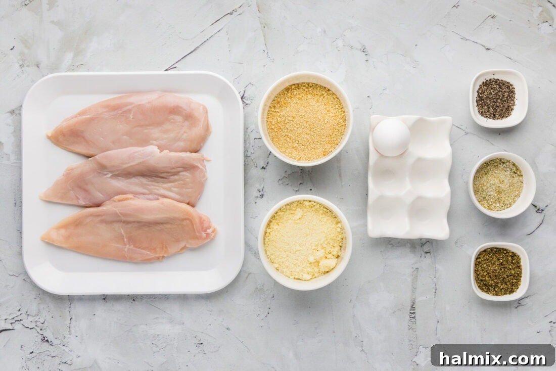 Crispy Parmesan Chicken 4 Ingredients for Parmesan Crusted Chicken laid out on a table