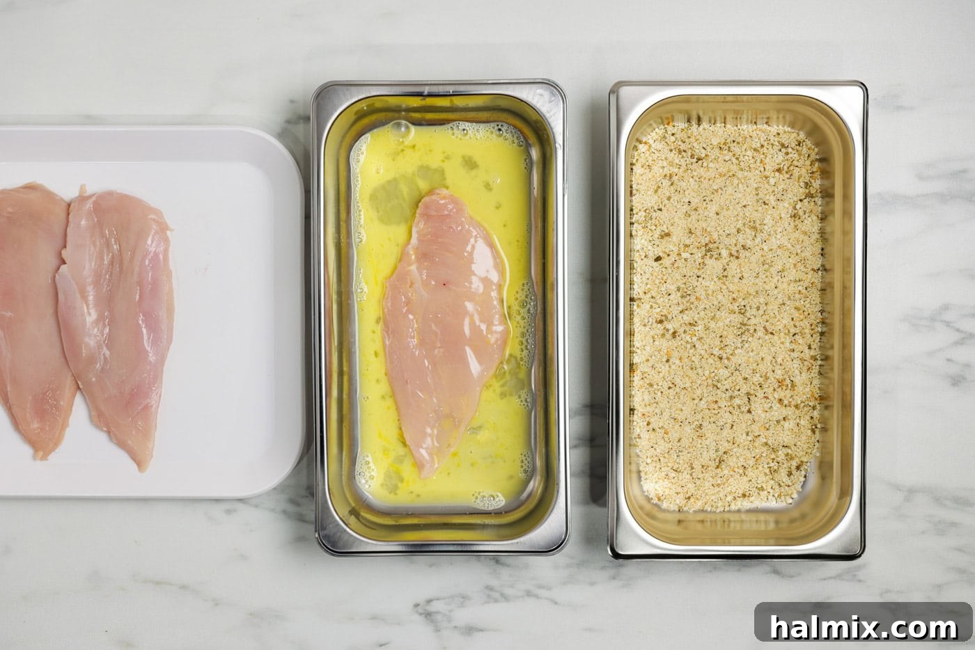 Crispy Parmesan Chicken 5 chicken breast in a breading tray with egg and water