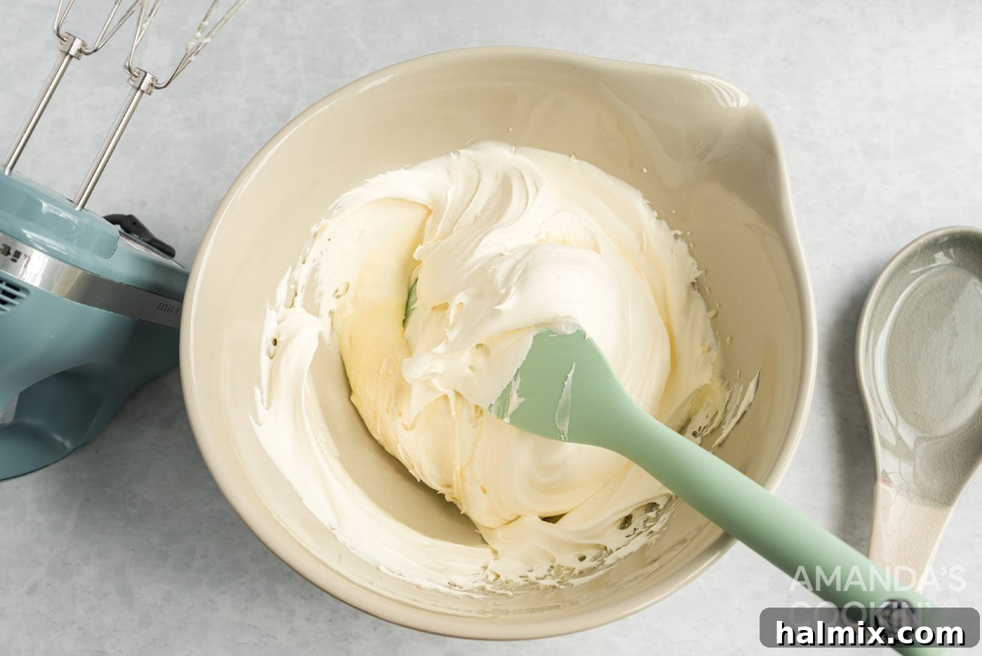 Gently folding whipped topping into the cream cheese and sugar mixture with a spatula, ensuring a light texture.