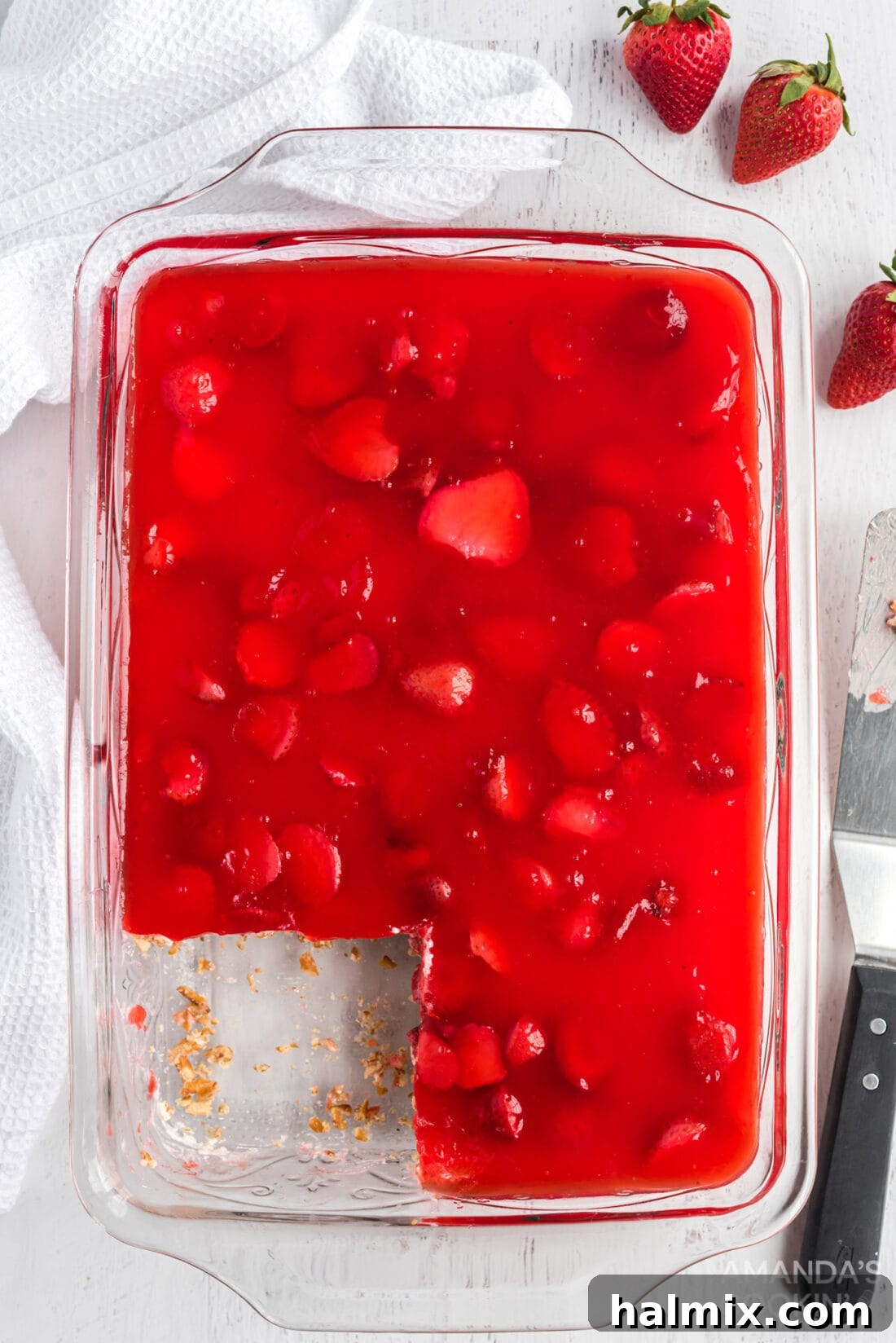 A pan filled with freshly prepared Strawberry Pretzel Salad, ready for chilling, showing its smooth cream cheese and jello layers.