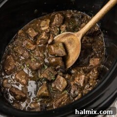 Close up photo of a spatula in a crockpot of Crockpot Beef Tips and Gravy