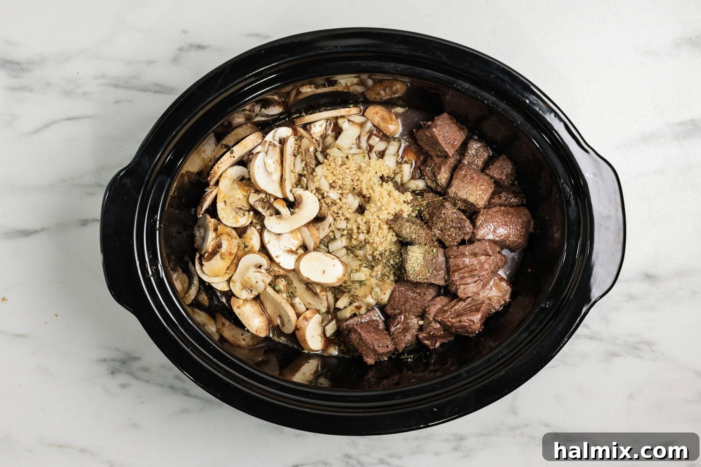 Browned sirloin cubes, onions, and mushrooms along with seasonings added to crock