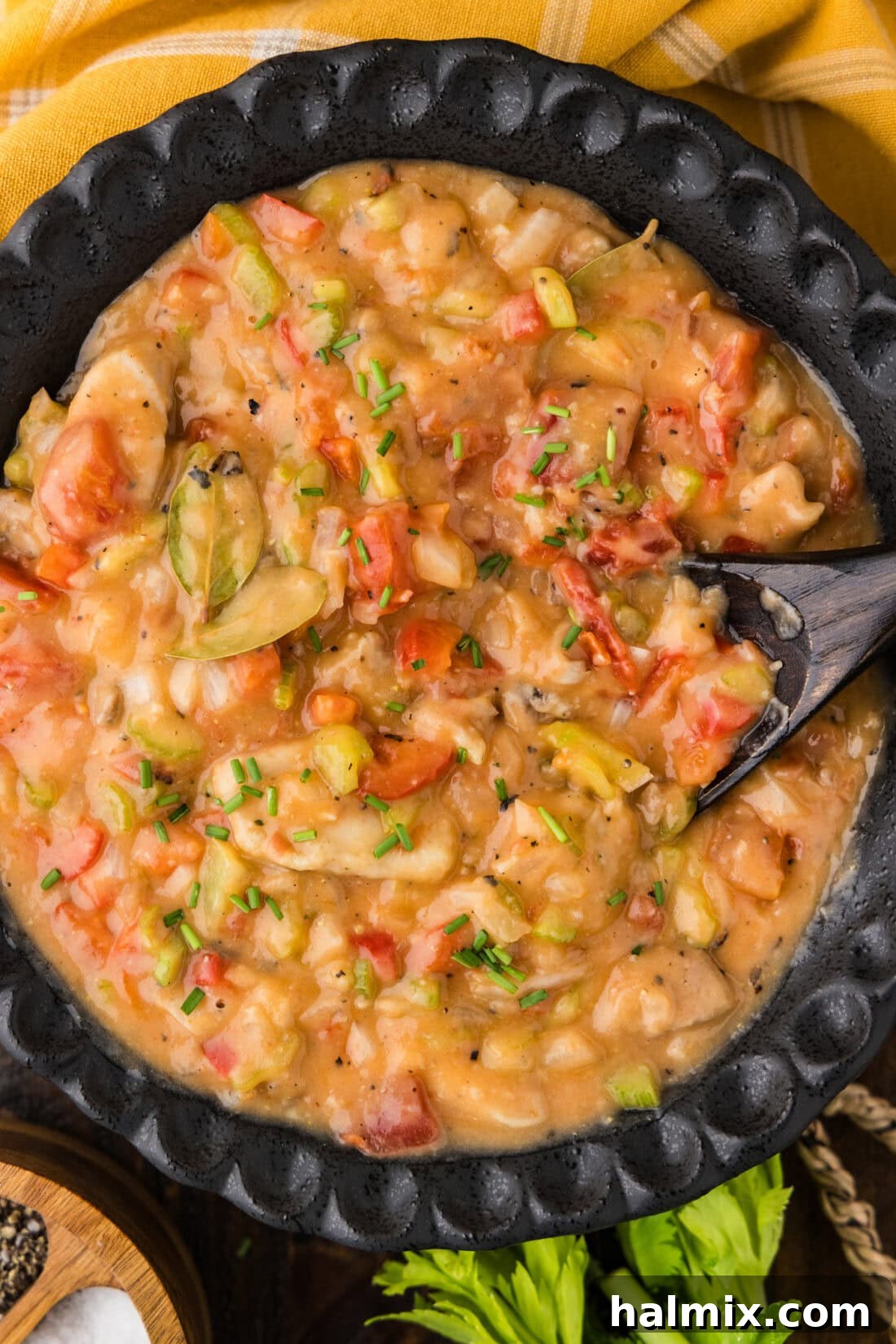 Close up photo of a bowl of Chicken Etouffee with a spoon in it