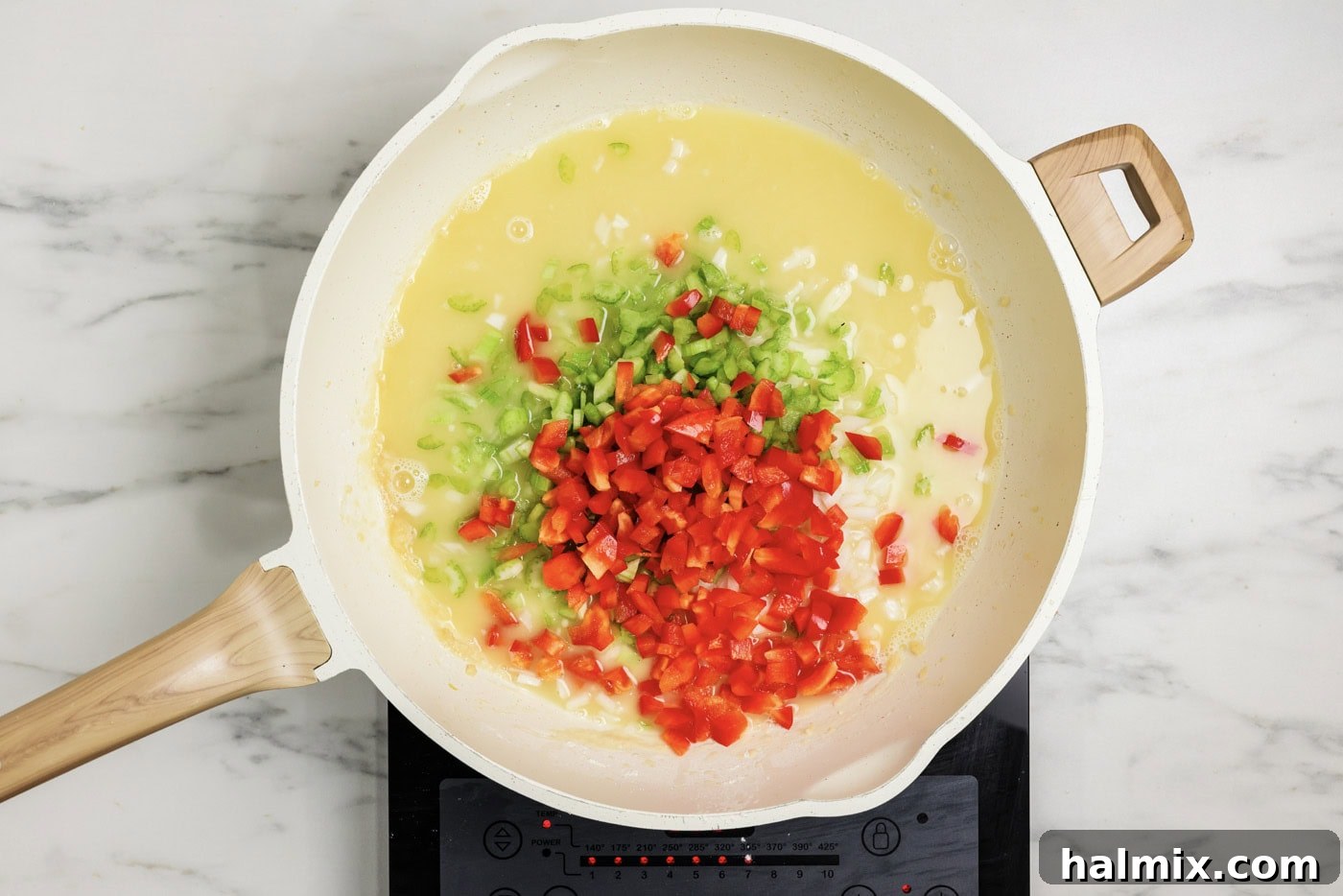 Onion, celery, and bell pepper added to roux in a skillet