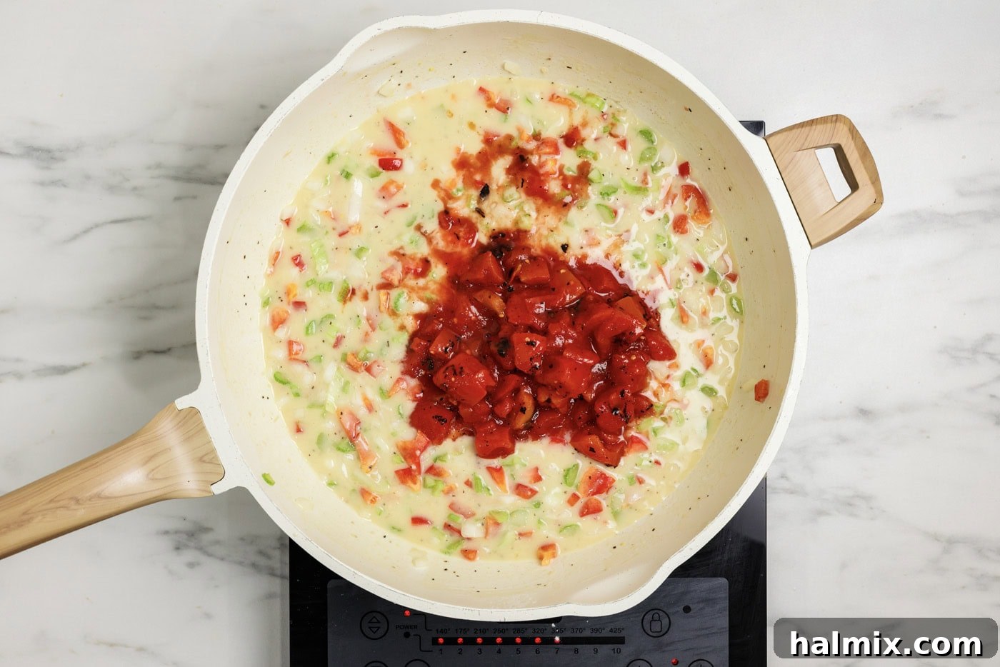 Canned tomatoes added to roux mixture in a skillet
