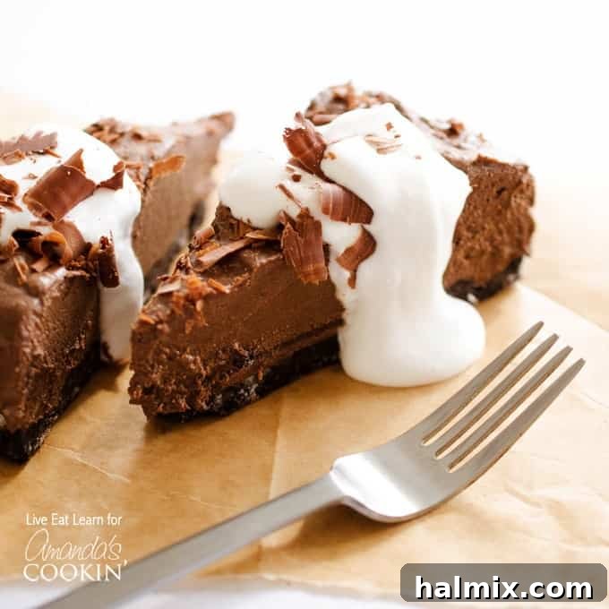 A close up of a slice of avocado chocolate mousse cake on a wooden cutting board with a fork next to it.