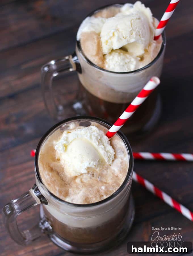 An overhead photo of two root beer float cocktails in clear mugs served with a red and white striped straw, showcasing the perfect presentation.