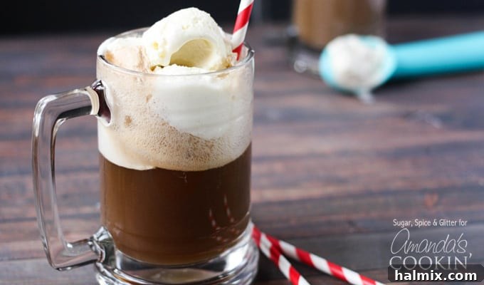 A photo of a single root beer float cocktail in a clear mug served with a red and white striped straw, highlighting the inviting texture.