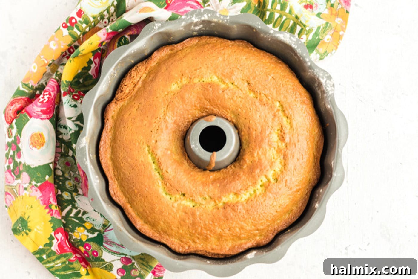 A freshly baked pistachio bundt cake cooling on a wire rack after being inverted from its pan.