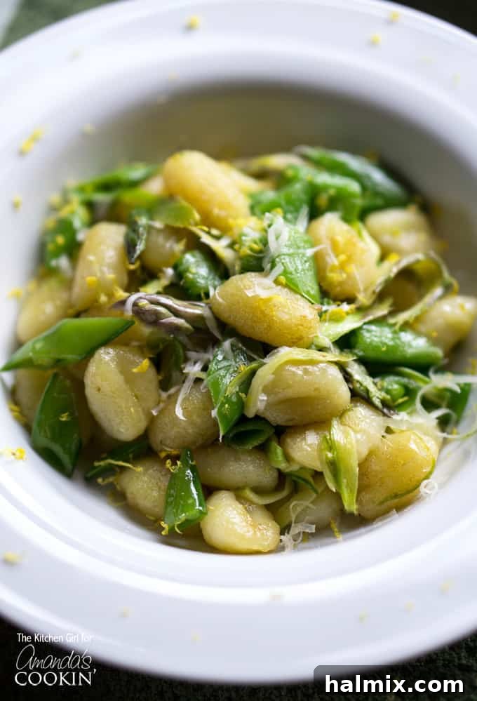 Crispy Gnocchi with Asparagus Ribbons and Snap Peas 5 A close up overhead photo of pan seared gnocchi with shaved asparagus and snap peas in a white bowl.