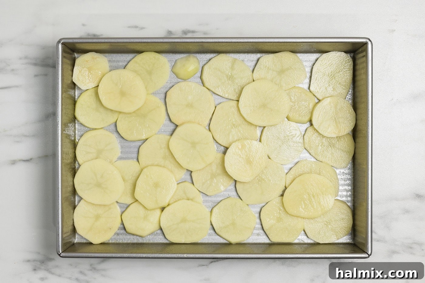 Thinly sliced potato rounds in a baking pan
