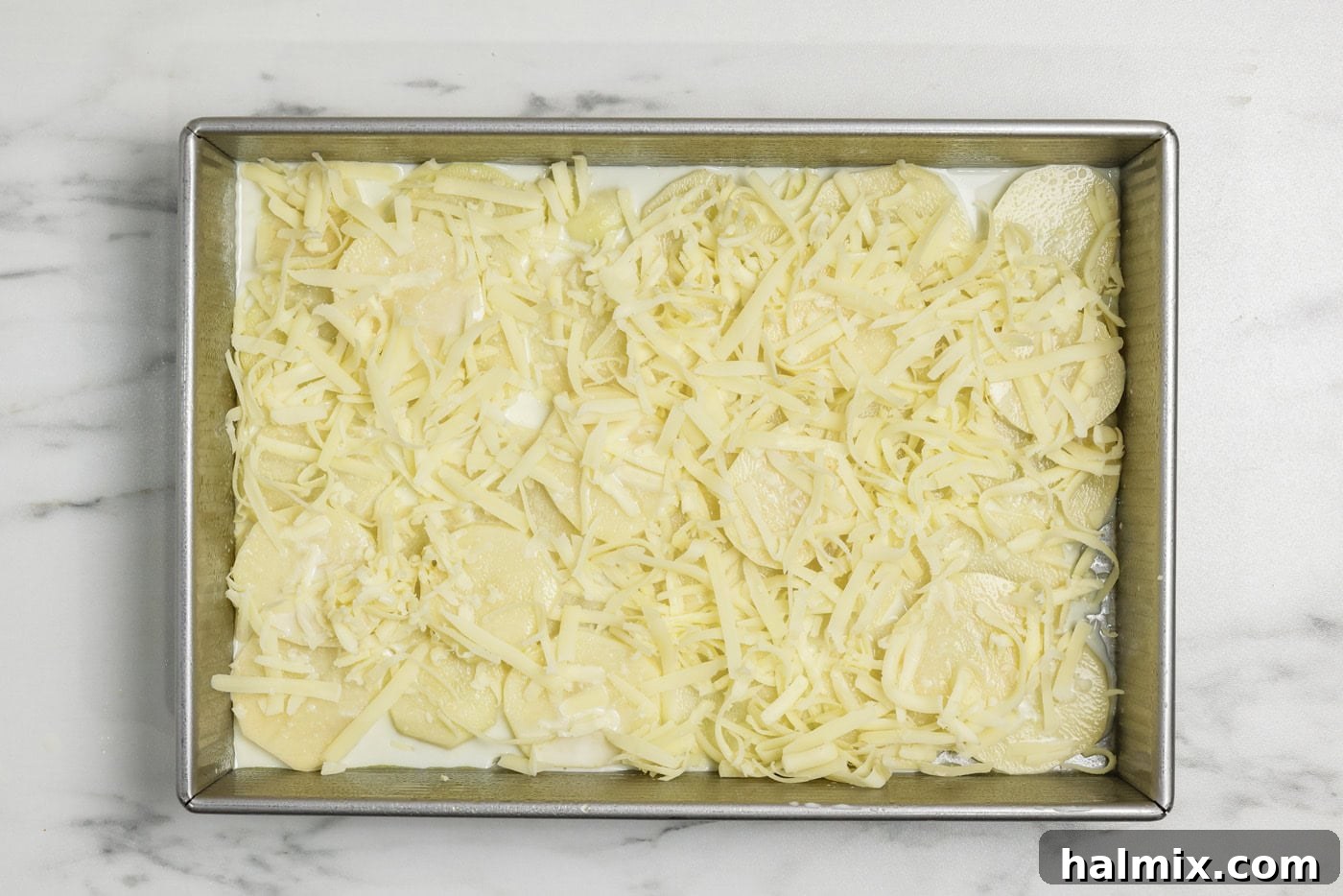 Layer of cheese on top of potatoes and sauce mixture