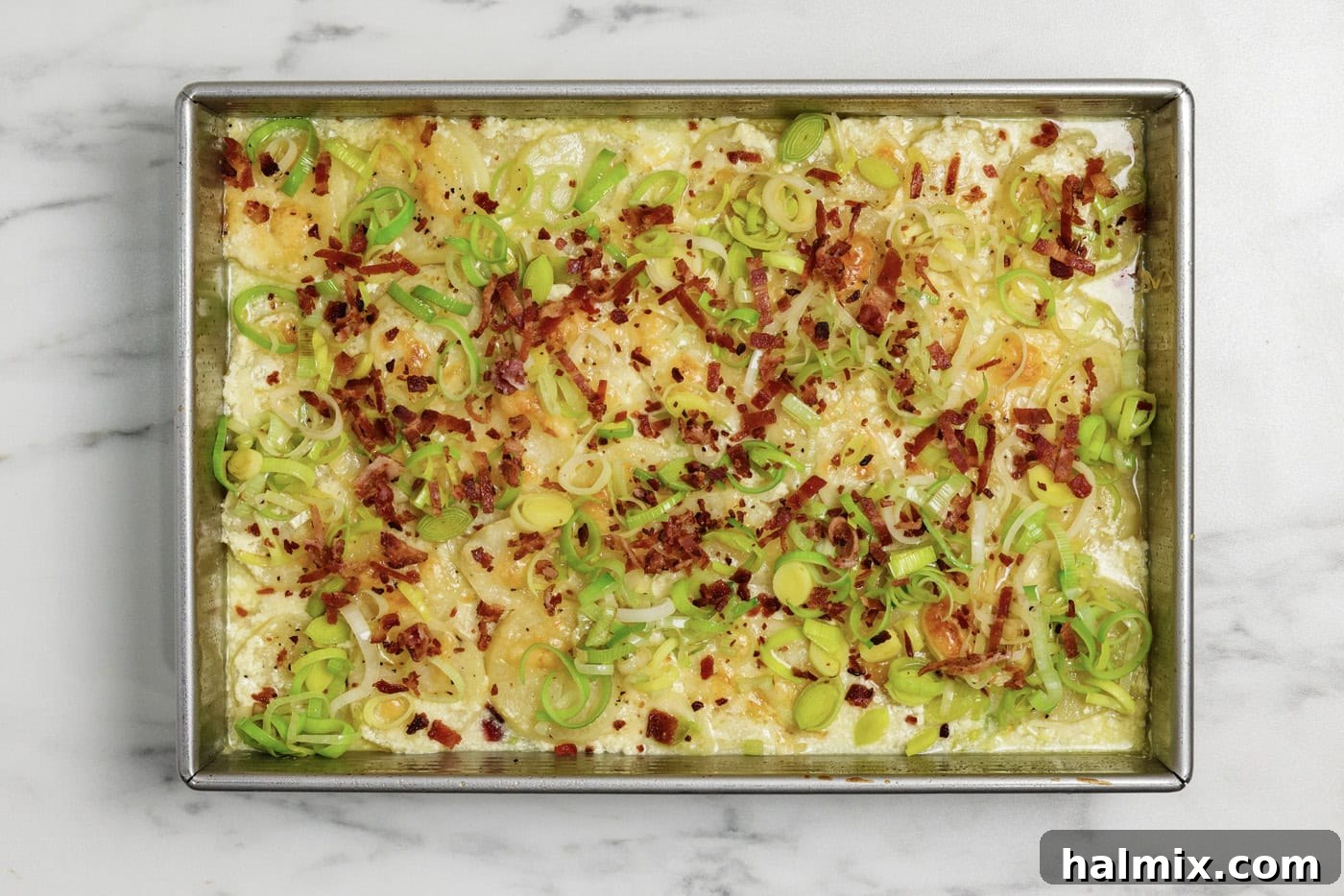Sauteed leeks and crumbled cooked bacon on top of potatoes au gratin