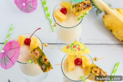 Three beautifully garnished Pina Coladas with cherries and pineapple.