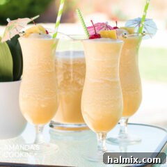 Three perfectly blended Pina Colada cocktails, garnished with pineapple slices and cherries, sitting on a table next to a swimming pool.
