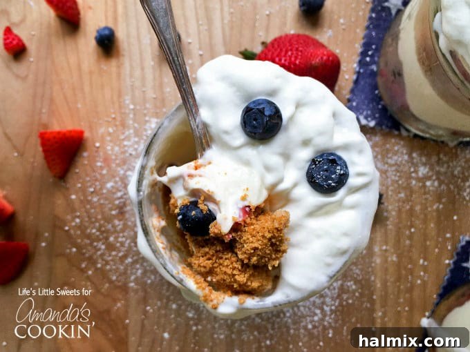 No-Bake Berry Cheesecake Trifle Jars 4 An overhead photo of a spoonful of no bake berry cheesecake trifle in a mason jar.