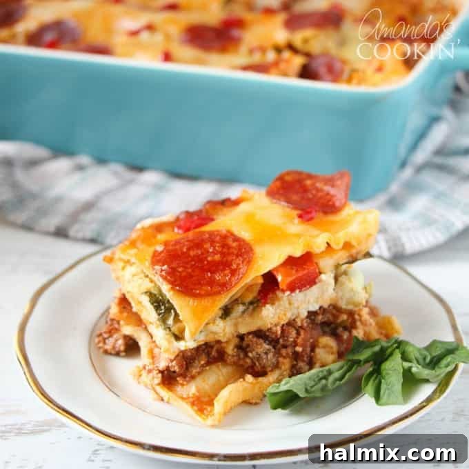 Layered Pizza Bake 2 A close up of pizza lasagna on a white and gold plate, showcasing melted cheese and savory layers.