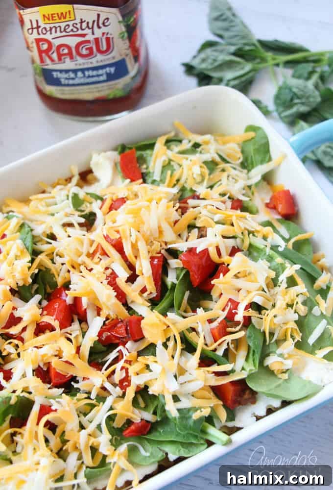 Layered Pizza Bake 14 A photo of additional shredded cheese sprinkled over the vegetable layer before final topping.