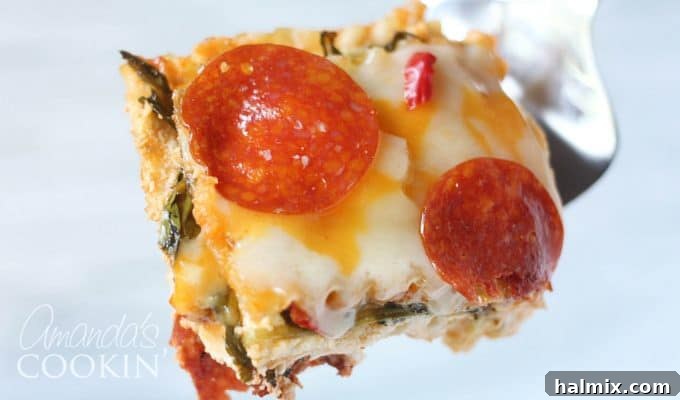 Layered Pizza Bake 17 A close up of a slice of pizza lasagna on a white and gold plate.