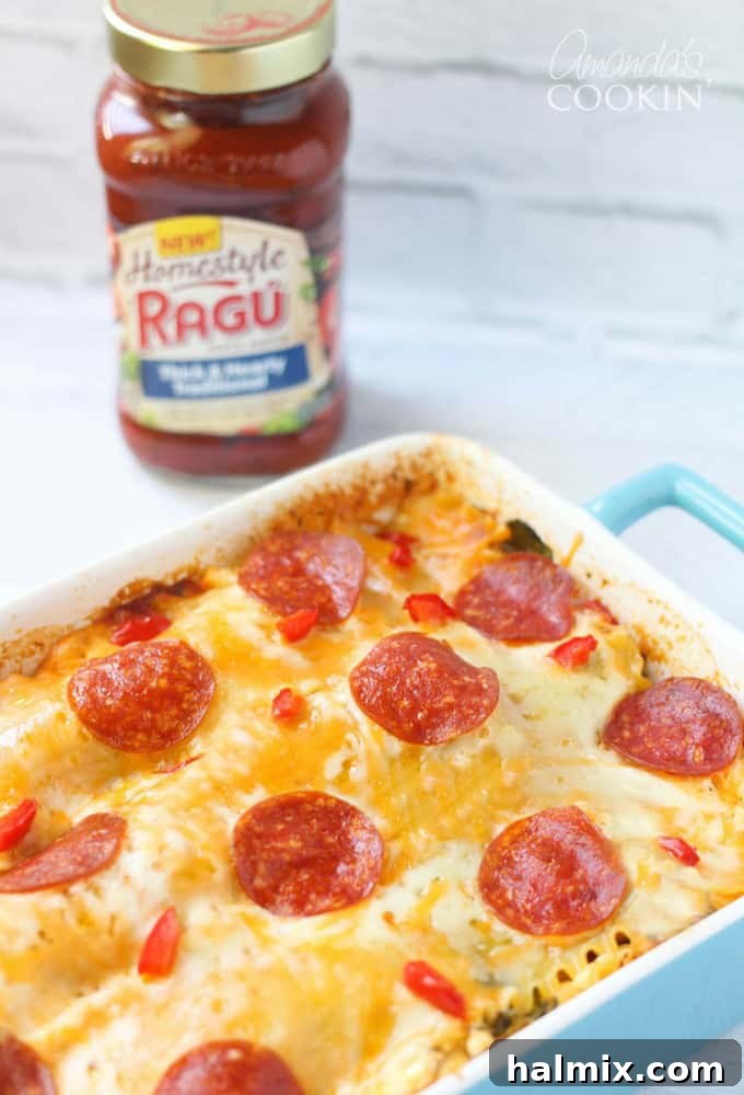 Layered Pizza Bake 3 A close up photo of freshly baked pizza lasagna in a blue casserole dish, bubbling with cheese.