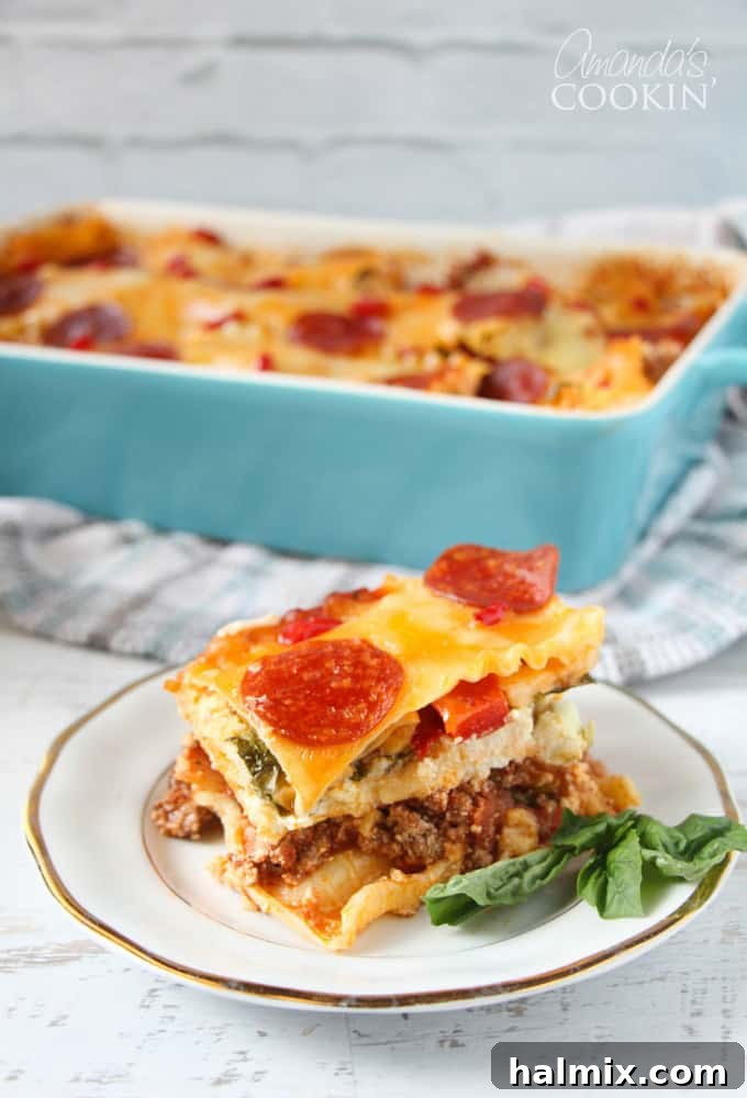 Layered Pizza Bake 4 A close up photo of a slice of pizza lasagna on a white and gold plate, with the full casserole in the background.