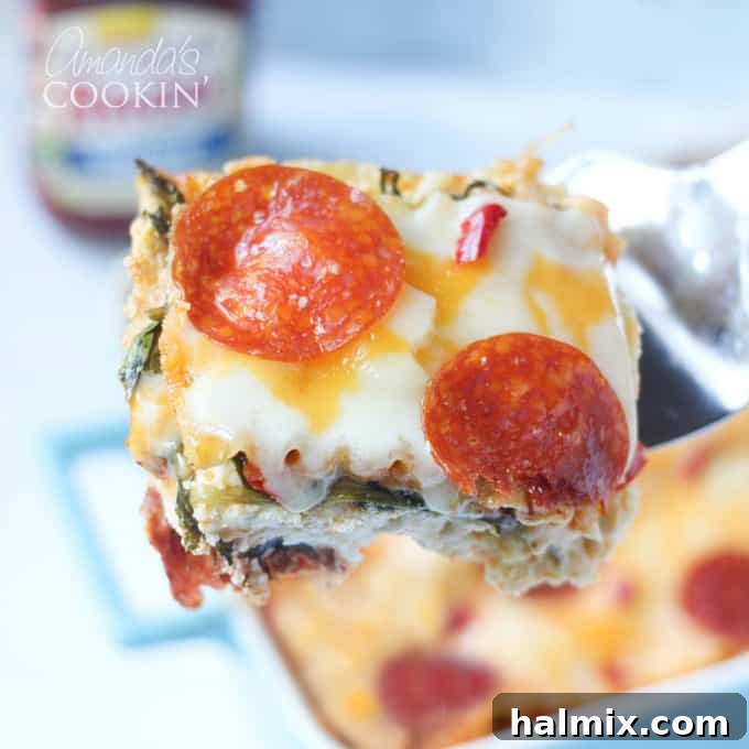 Layered Pizza Bake 5 A close up of a serving of pizza lasagna being lifted with a spatula, showing the layers.