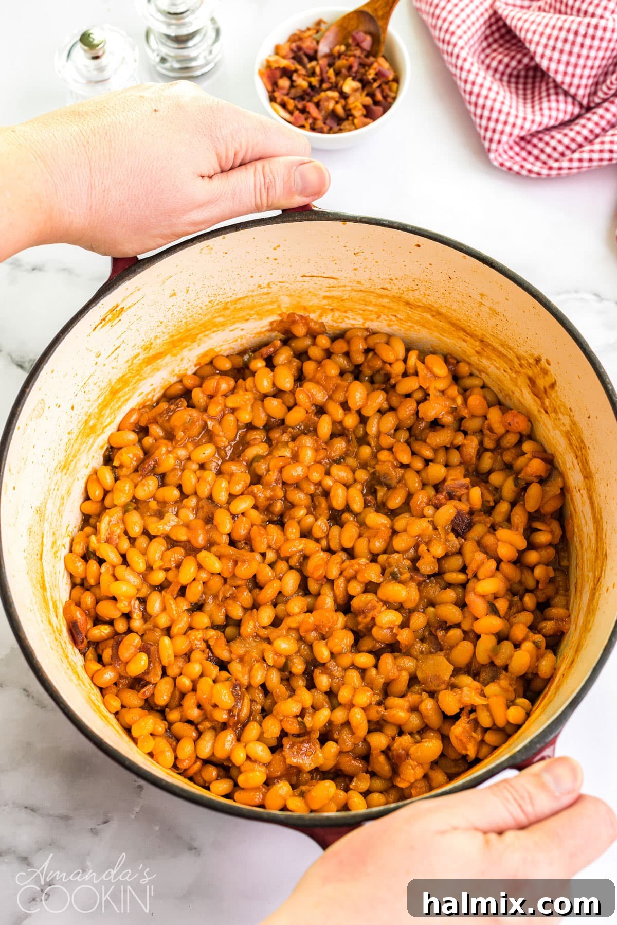 dutch oven full of homemade baked beans being carried to the table