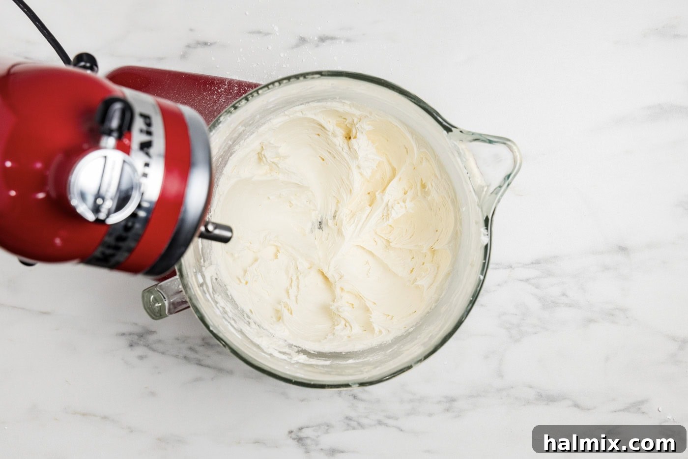 Marshmallow fluff frosting being prepared in a stand mixer bowl