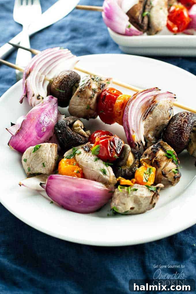 Succulent Grilled Chicken Skewers 2 A close up photo of marinated grilled chicken skewers on a white plate.