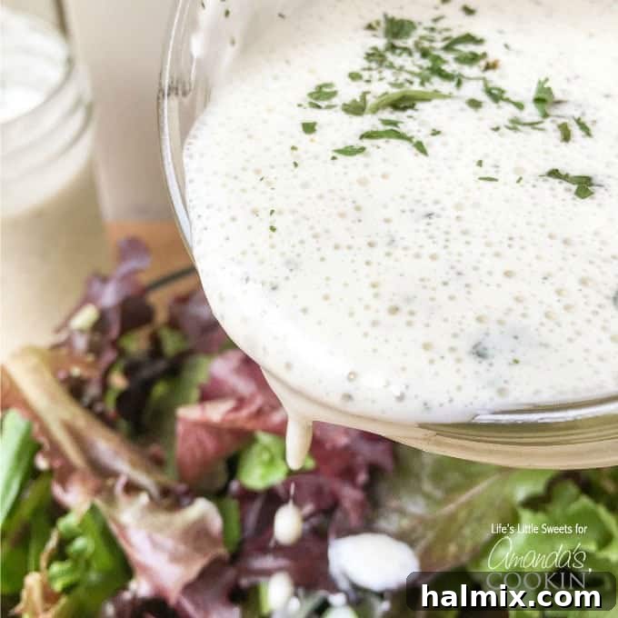 Try this delicious buttermilk ranch dressing recipe at home instead of buying another bottle. This homemade ranch dressing is creamy, delicious and fresh! Creamy buttermilk ranch dressing being poured from a bowl over a fresh green salad