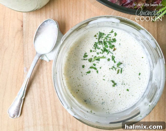 Try this delicious buttermilk ranch dressing recipe at home instead of buying another bottle. This homemade ranch dressing is creamy, delicious and fresh! Overhead shot of creamy buttermilk ranch dressing in a white bowl, garnished with fresh herbs