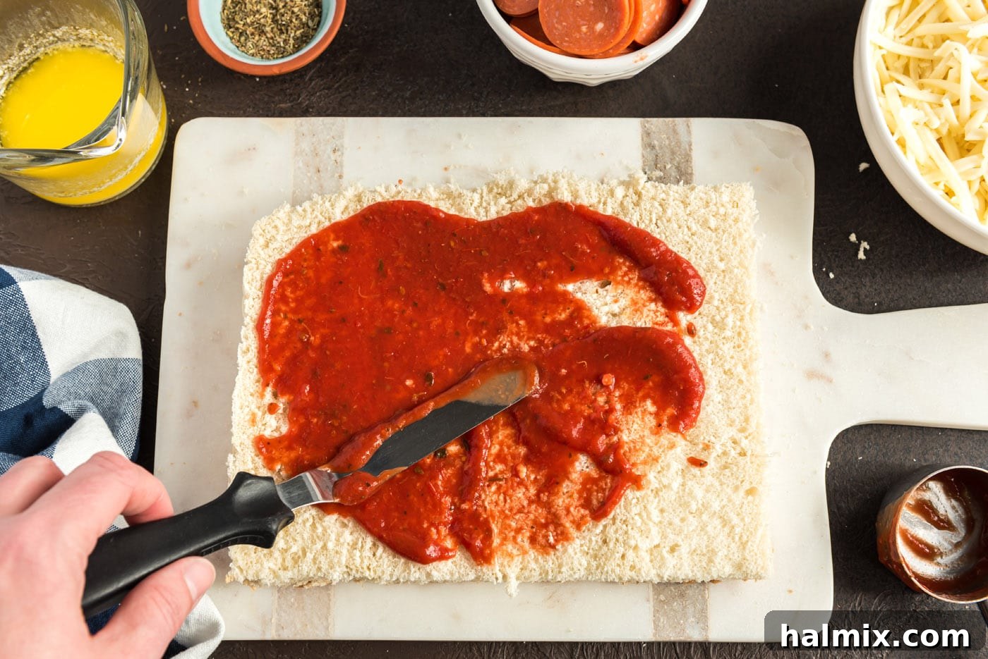 Cheesy Pizza Buns 6 spreading pizza sauce over slider buns