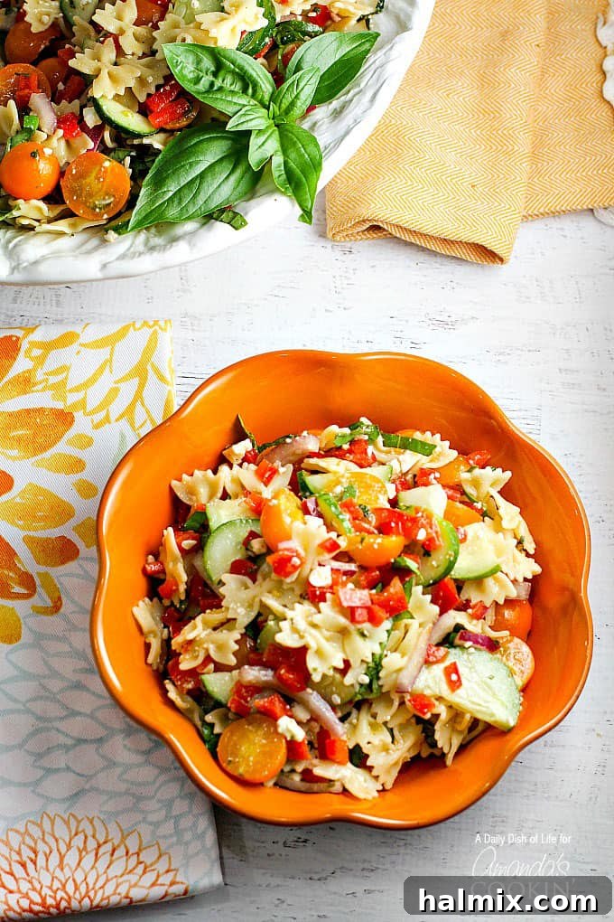 Vibrant Summer Pasta Salad 2 Summer pasta salad in a vibrant orange bowl, showcasing fresh vegetables and pasta.