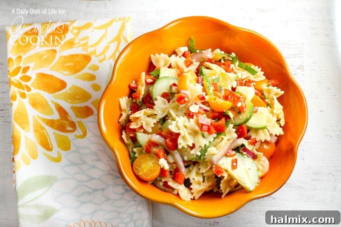Vibrant Summer Pasta Salad 5 An orange bowl filled with the colorful summer vegetable pasta salad.