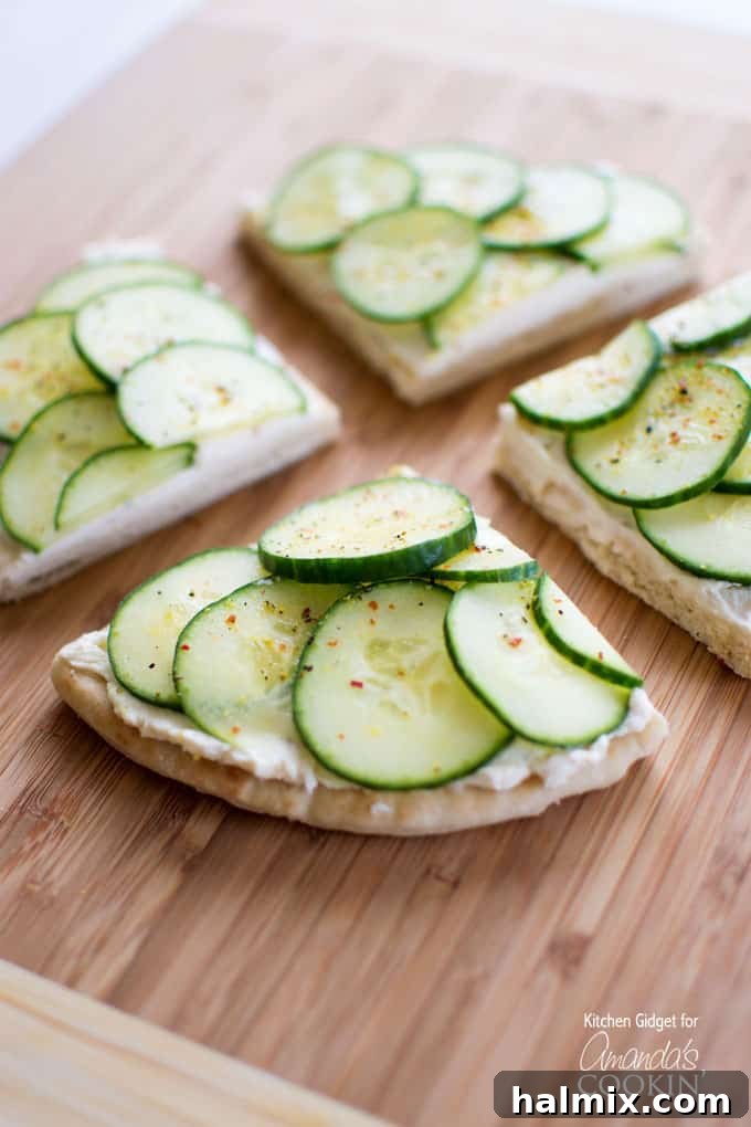 Cucumber Sandwiches: The Ultimate Refreshing Appetizer Crisp cucumber sandwiches with seasoned cream cheese on soft pita bread, arranged attractively on a platter.