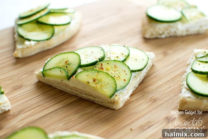 A Closer Look at Deliciousness Close-up of a cucumber sandwich wedge, showcasing the layers of pita, cream cheese, and thin cucumber slices.