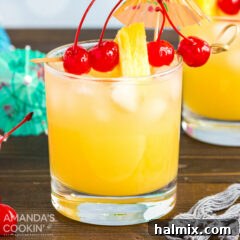 A glass of Mai Tai cocktail with cherry and pineapple garnish