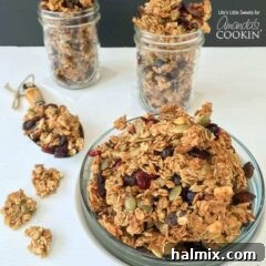 A photo of a plate of autumn harvest fruit and nut granola and two filled mason jars in the background.