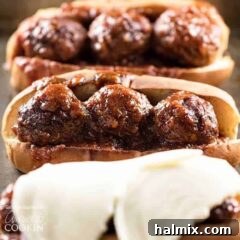 Saucy Slow Cooker BBQ Meatball Heroes 6 A close up photo of three slow cooker BBQ meatball subs, one topped with provolone cheese.