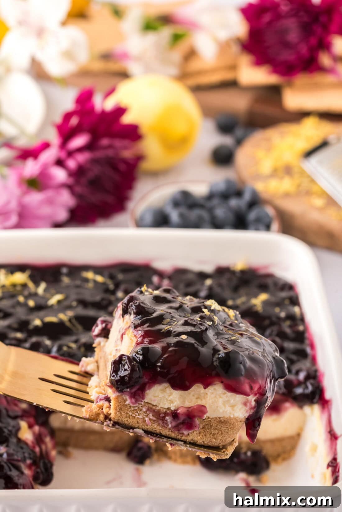 Spatula lifting up a slice of No Bake Blueberry Cheesecake, showcasing its delicious layers