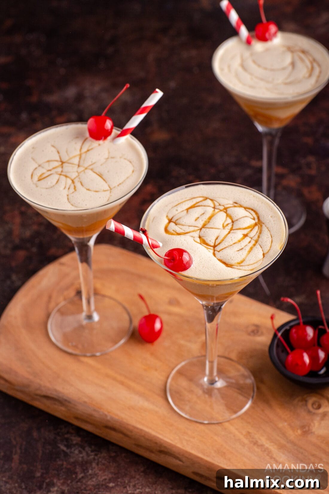 Spiked Butterscotch Shake 3 A close-up shot of a butterscotch milkshake cocktail in a martini glass with a cherry garnish, showcasing its creamy texture.