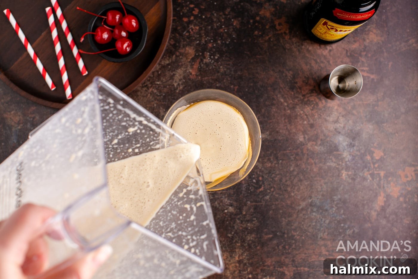 Spiked Butterscotch Shake 7 A creamy butterscotch milkshake cocktail being poured from a blender into a prepared martini glass.
