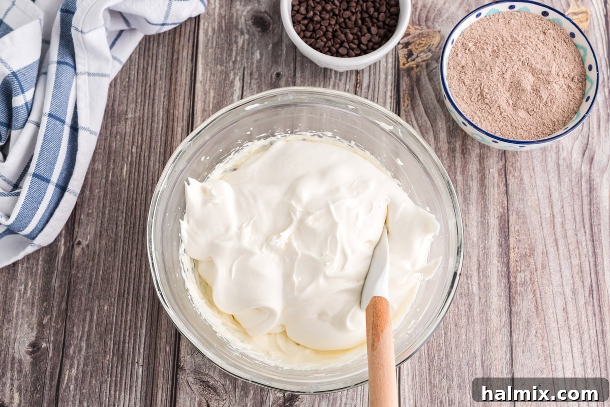 Cool whip added to the bowl of cream cheese mixture