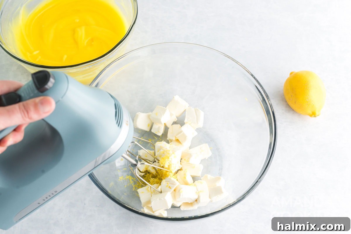 Beating softened cream cheese with lemon zest in a stand mixer until creamy.
